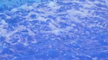 Dekoratif bir şenlik çeşmesinin köpüren renkli mavi suyu pürüzsüz dalga hareketleriyle