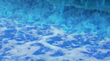 Soyut mavi sıvı dalgalar, sıçramalar ve beyaz köpükler kapanıyor.