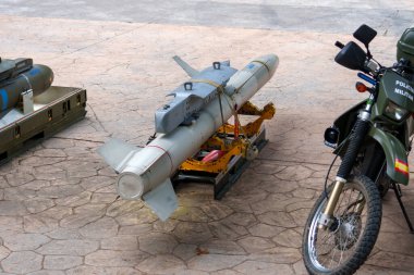 Oviedo, İspanya - 25 Mayıs 2024: Sarı bir platformda gri bir eğitim füzesi askeri polis tarafından İspanyolca yazılmış yeşil bir motosikletin yanına park edilmiştir.