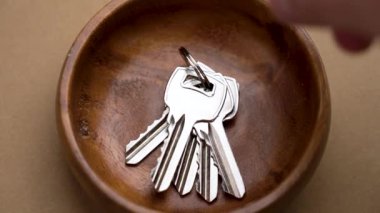 Evin erkek sahibi ayrılmadan önce koridor rafındaki tepsiden birkaç daire anahtarı almış.