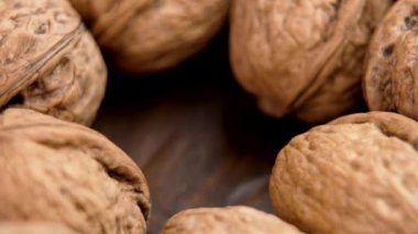 Ceviz kabuksuz fındık yığınının içine düşer, kahverengi kabukları ve desenli yüzeyi yakın plan vurgulanır. Makro