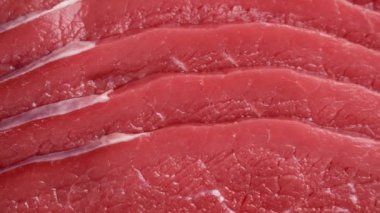 Çiğ sığır eti dilimleri kırmızı etin renklendirme dokusunda yakın çekim gösterilir. Protein sağlıklı yiyecekler. Döndürme