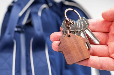 Mavi bavul arka planında turistlerin kullandığı ahşap bir ev şeklindeki anahtarlık. Seyahat hazırlama konsepti