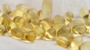 D-3 vitamini kapsülleri yavaş çekimde düşüyor. Beslenme takviyeleri. Makro çekim