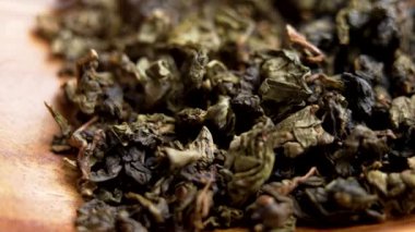 Geleneksel oolong yeşil çayı ahşap bir kasede. Kurutulmuş kıvırcık yapraklar. Makro atış. Döndürme