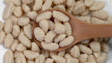 Ahşap bir mutfak kaşığında pişirilmemiş ev yapımı gnocchi yakın çekim. Çiğ İtalyan İçindekiler