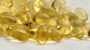 Sarı E vitamini bej kumaşlı şeffaf kapsüller. Makro atış. Döndürme