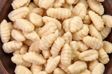 Ahşap kasede pişmemiş patates gnocchi köftesi. Lezzetli çiğ İtalyan yemeği malzemesi. Üst görünüm