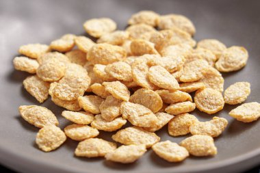 Gri kasede yemek pişirirken besleyici kahvaltı gevrekleri düşer. Sağlıklı besin maddeleri