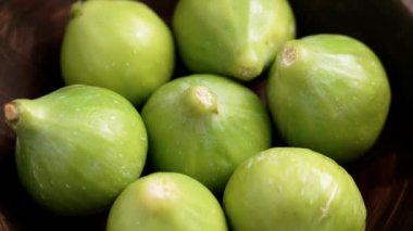 Dolu ahşap kase ve sulu incirleri yakın mesafeden yemeye hazır. Sağlıklı meyve malzemeleri. Döndürme