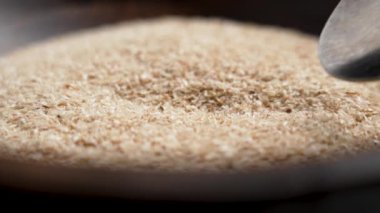 Kaşık, ahşap kaseden sağlıklı organik iyileştirici psyllium kabuğu topluyor. Süper gıda takviyesi. Makro çekim