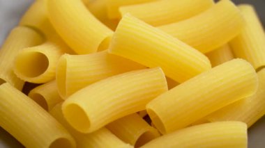 Mutfak kasesinde pişmemiş İtalyan usulü makarna. İtalya 'da geleneksel makarna. Buğday bileşeni. Döndürme