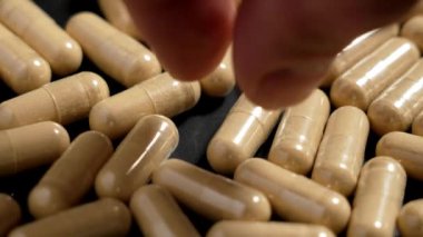 Adaptojen Ashwagandha kök özütü alternatif bitkisel ilaç kapsüllerinde. El sakinleştirici hap alıyor. Makro çekim