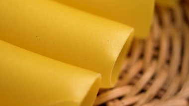 Özel pişirilmemiş glütensiz İtalyan Cannelloni makarnası ve rattan rustik mutfak kasesi. Silindirik tip organik geleneksel malzeme. Makro atış. Döndürme