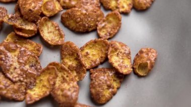 Kahvaltılık mısır gevreği, çikolatalı gevrek, mutfak seramik gri kasede. Çiğ, sağlıklı malzeme. Makro atış. Döndürme