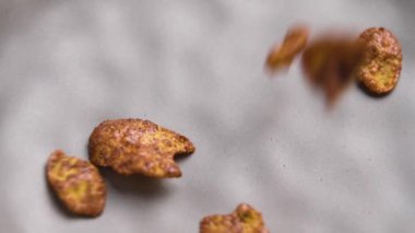 Sabah kahvaltısı. Çikolatalı mısır gevrekleri ağır çekimde gri mutfak kasesine dökülüyor.