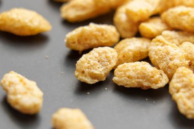 Tarafsız gri seramik üzerinde işlenmiş yulaf tanelerinin makro çekimi.