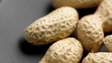 Kavrulmuş kabuksuz fıstık ve siyah. Makro doku. Döndürme