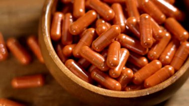 Orange Lutein Kapsülleri ve Calendula Petal Bitkisel Özütü bir tahta kasede. Göz Sağlığı ve Görüş Beslenme Desteğini Destekliyor. Işık Hareketi