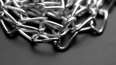 Siyah üzerine parlak halkalar takılmış metal krom zincir. Döndürme. Makro çekim