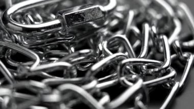 Karabina kancalı ve bağlı halkalı parlak metal krom zincir. Makro. Döndürme