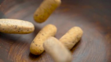 Gevrek mini ekmek ruloları (picos) ağır çekimde ahşap bir kaseye düşüyor. Ekstra zeytinli tipik İspanyol Endülüs mutfağı. Kırsal görünüm