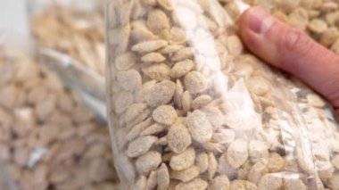 Bir paket mısır gevreği tutan adam sağlıklı bir diyet için dokuya ve doğal kalitede kepekli tahıl gevreği tutuyor.