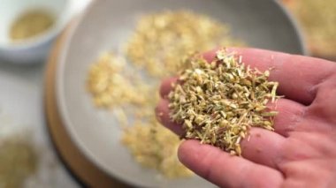 Kurumuş kireçlenmiş şifalı bitkiler nazikçe ellerinden dökülerek Ayurveda ve bitkisel gelenekler yoluyla doğal iyileşmenin özünü yakalıyorlar. Yavaş çekim