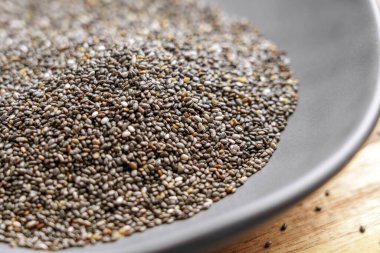 Minimalist bir kasede kurutulmuş chia tohumları, besin değeri yüksek doğal bir organik gıda sergiliyor. Temiz yemek, sağlıklı beslenme ve sağlıklı beslenme için ideal.