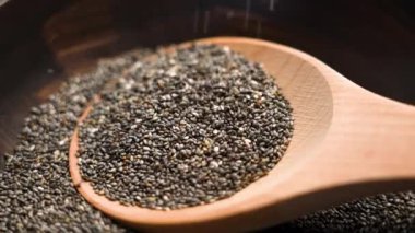 Tahta kaşık ve düşen chia tohumları zengin besin değerlerini ve organik kalitelerini ön plana çıkarıyor. Kahvaltı kâselerine ya da fitness yemeklerine eklemek için mükemmel. Yavaş çekim