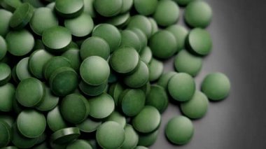Minimalist bir tabakta yeşil spirulina yosun tabletleri. Bitki bazlı takviyeler sağlık, temiz beslenme ve doğal sağlığa odaklandı. Döndürme. Üst görünüm