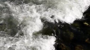 Güçlü nehir akıntısı kayalık nehir yatağının üzerinden akıyor. Beyaz su girdapları dinamik hareket yaratır. Temiz ve taze ortamda yakalanan doğa enerjisi.