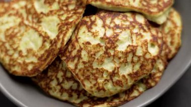 Kabak, psyllium ve pirinç unundan yapılmış ev yapımı vejetaryen krepleri. Yeşil benekli ve yumuşak desenli altın kahverengi kabuklu. Döndürme. Üst görünüm