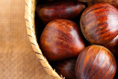 Kırsal kahverengi arka planda dokuma sepetinde kestane topladım. Kapatın. Üst görünüm