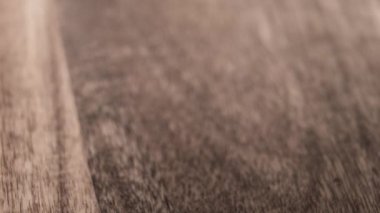 Siyah katmanlı polistiren köpük tabakası yavaş çekimde ahşap yüzeye düşüyor.