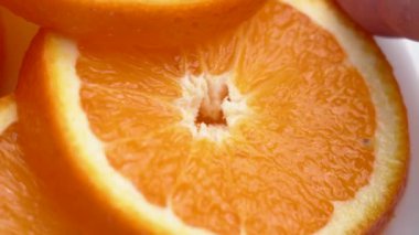 Eline taze organik portakal dilimi alır. Yaz dilimlenmiş tropikal meyve vitamini. Makro çekim