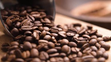 Kavrulmuş kahve çekirdekleri, ağır çekimde metal kaplardan dökülen organik aromatik robusta tanelerine dökülüyor. Kırsal görünüm