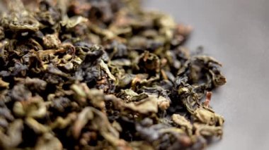 Daire üzerinde kurumuş yeşil çay yaprakları. Geleneksel içecek malzemesi. Aroma yaprağı. Makro. Döndürme