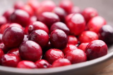 Fresh cranberries (Vaccinium macrocarpon). Organic berry in kitchen bowl. Macro shot clipart