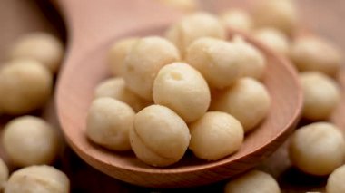 Tahta kaşıkta Macadamia fındığı. Makro atış. Döndürme