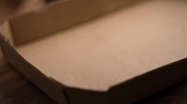 Altın mısır gevrekleri karton ambalaja düşüyor. Diyet gevrek kepekli atıştırmalık. Doğal ahşap yüzey. Yakın plan. Yavaş çekim