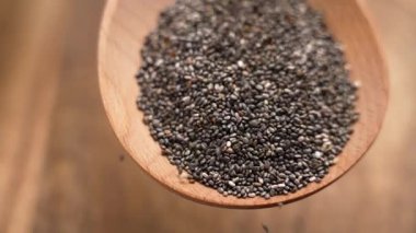 Kırsal masada tahta bir kaşıkta küçük chia tohumları yığını. Sağlıklı organik bileşen. Yakın plan..