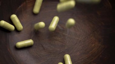 Bağışıklık desteği quercetin tabletleri bromelin özüyle ağır çekimde ahşap bir kaseye düşüyor. Beslenme takviyeleri. Döndürme