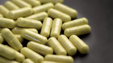 Seramik bir kasede bromelin özü bulunan bağışıklık desteği quercetin kapsülleri. İlave haplar. Makro. Döndürme