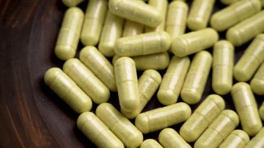 Tahta bir kasede bromelin özü bulunan yeşil kapsüller. Doğal takviyeler. Üst Manzara. Döndürme