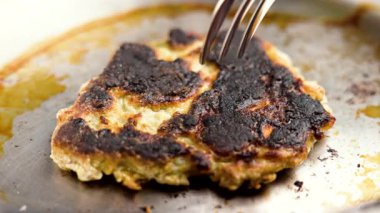 Çatal kullanarak tavadan yanmış bir krep almak. Makro çekim