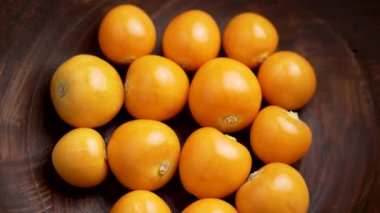 Tahta bir kasede taze Bektaşi Burnu (Physalis) meyvesi. Üst Manzara. Makro atış. Döndürme
