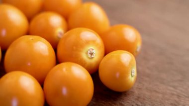 Physalis meyveleri ya da ahşap masada kirazlar. Makro. Döndürme