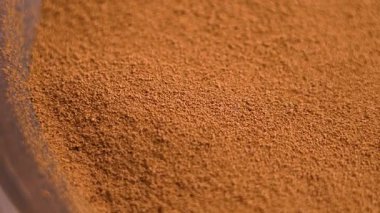 Yerdeki hindiba tozu, eko dostu ahşap bir kaseye yavaş çekimde düşüyor. Sağlıklı bir içecek karışımı. Makro çekim