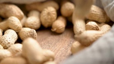 Kabuksuz fıstıklar, bez peçeteyle ahşap masaya düşüyor. Makro çekim